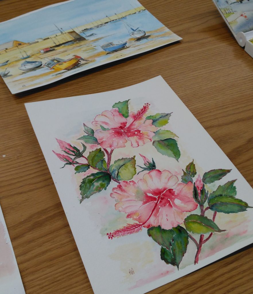 Two watercolours, one of pink flowers and one of a harbour with the tide out.