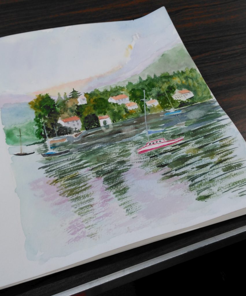 A sketchpad opened to a scene of boats on a lake.