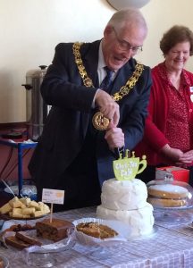 The mayor of Winchester cutting a cake at the Chat-Tea Café
