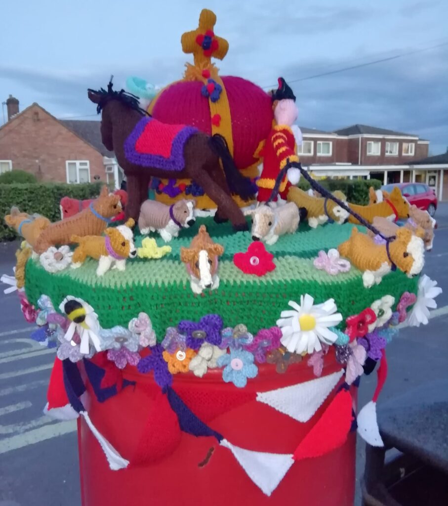 A yarn bomb on Oliver's Battery post box featuring the Queen and her corgis