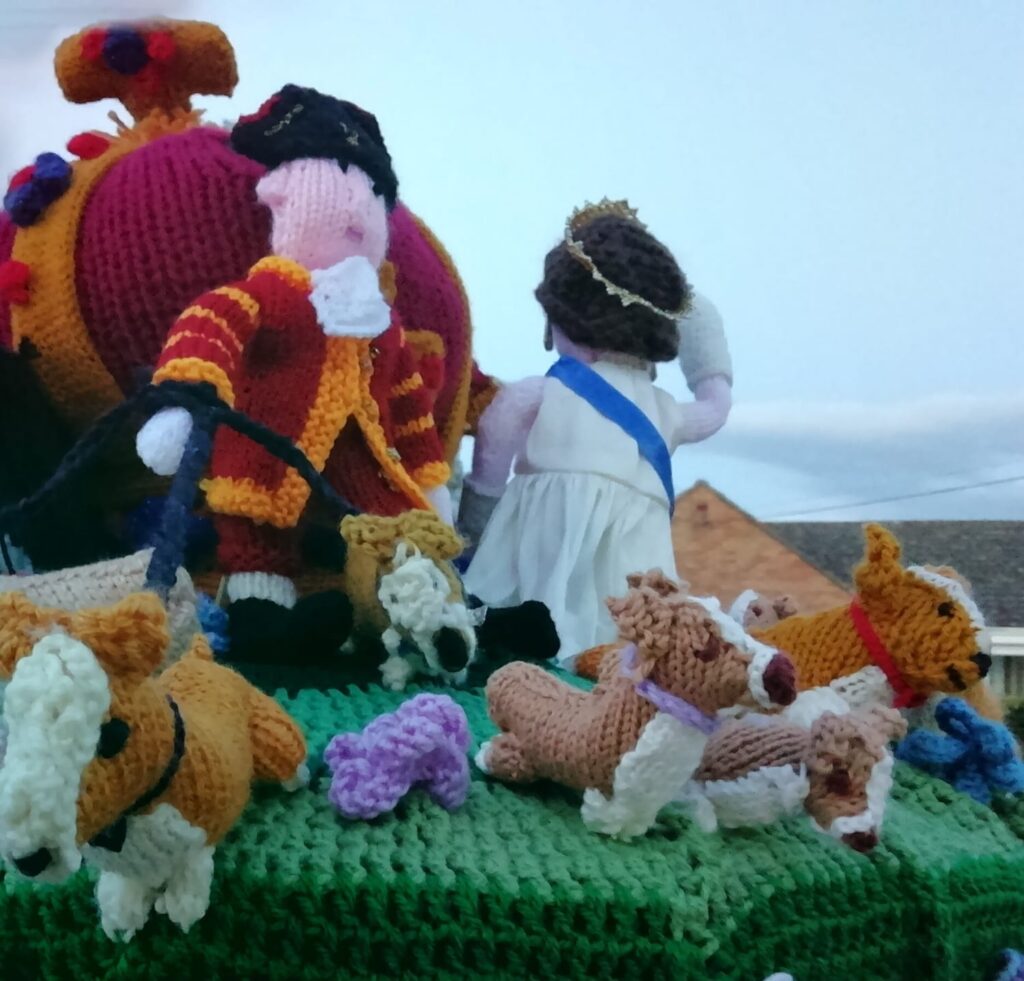 A yarn bomb on Oliver's Battery post box featuring the Queen and her corgis