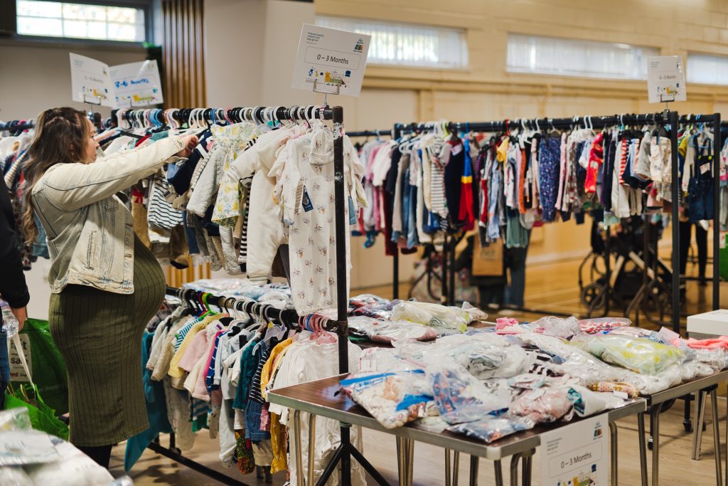 Racks of preloved baby clothes at an NCT Nearly New Sale.