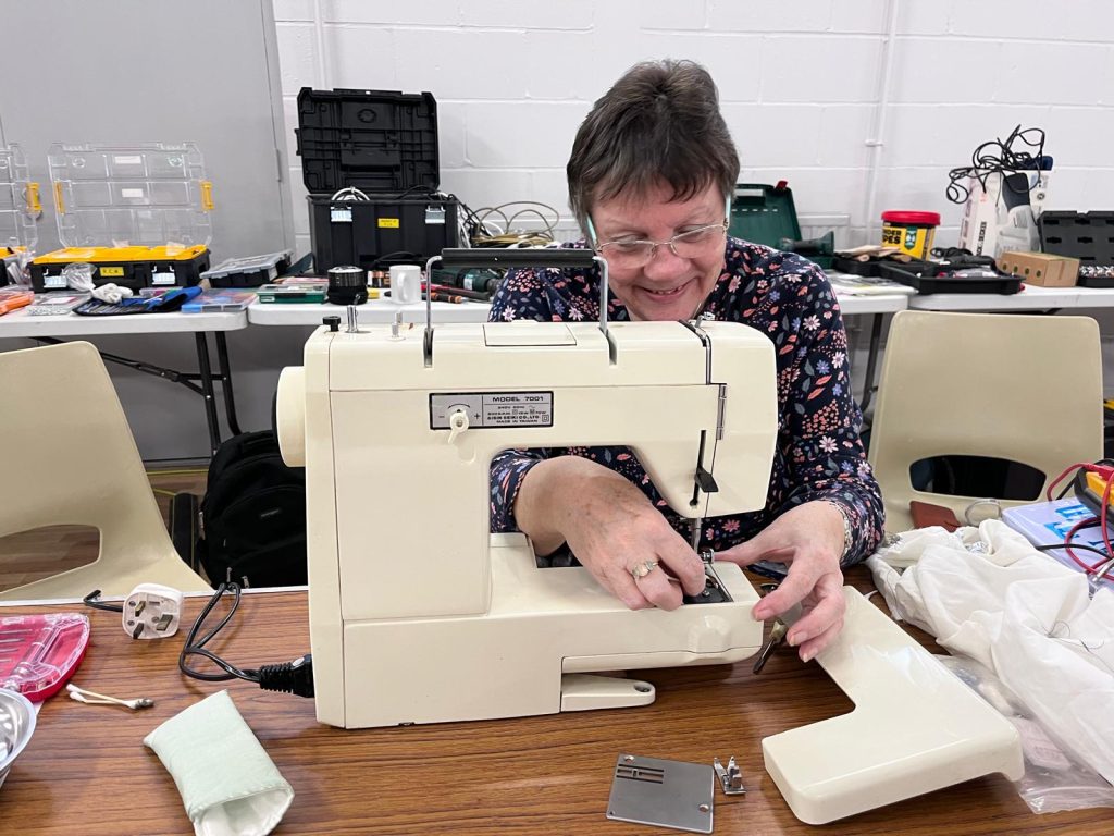 A lady using a sewing machine at Repair Café Winchester