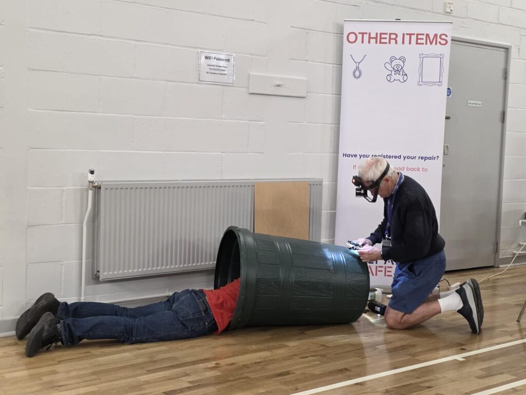 2 men repairing a bin - fix it don't bin it! Repairers Included.